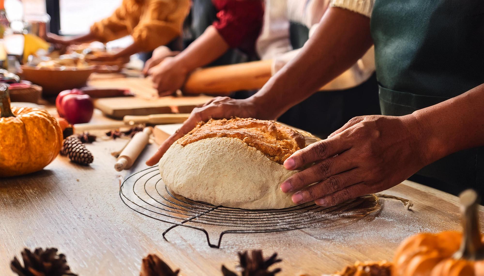 Chefs demonstrating bread shaping to students